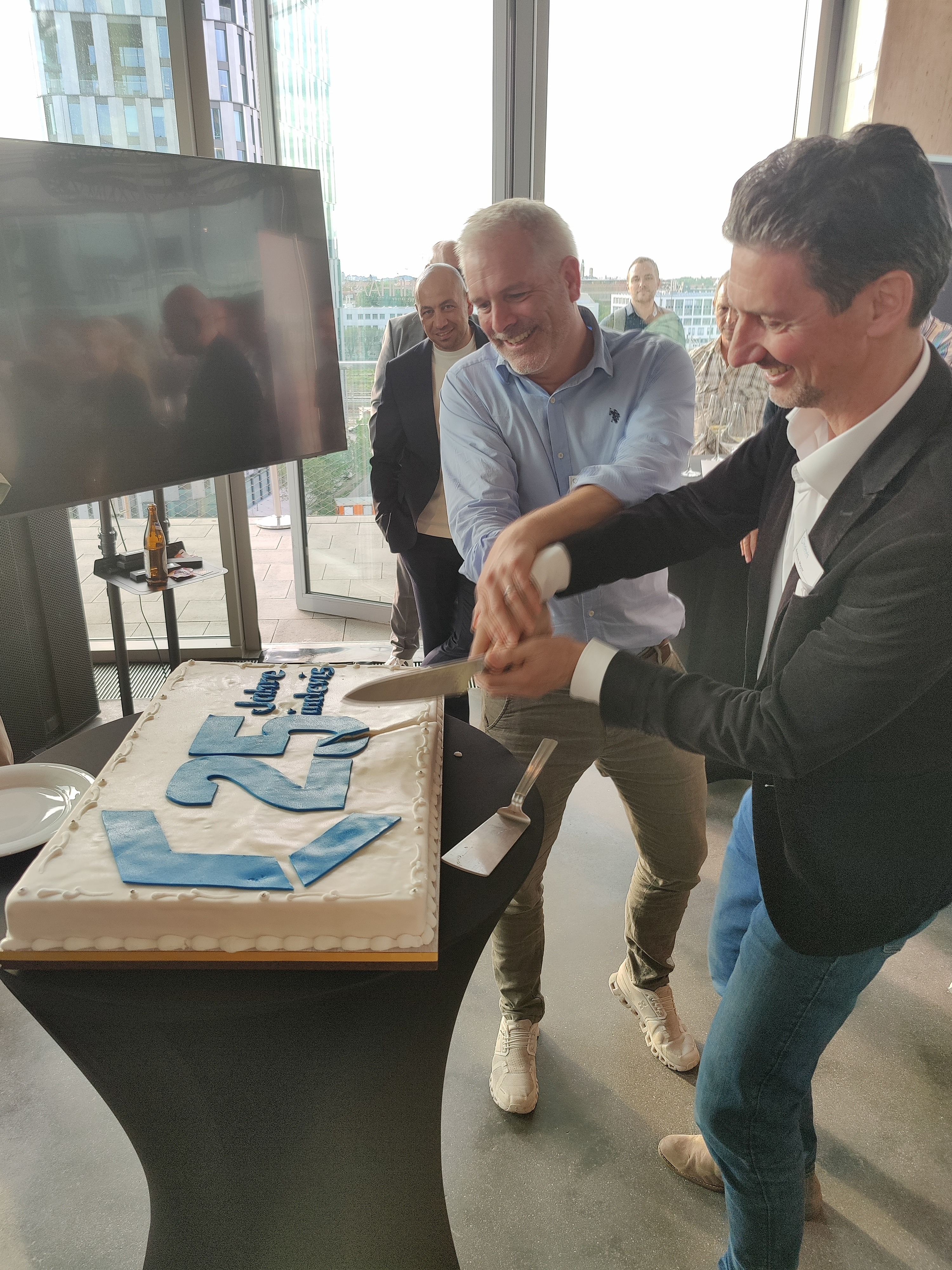 indevis insights Jubiläumsfeier Gründer Wolfgang Kurz und Andreas Mayer schneiden die Torte an